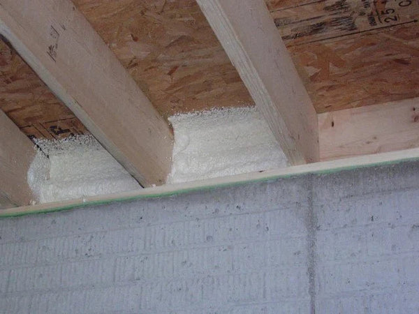 Roll of perforated foil radiant barrier insulation extending out from a cardboard shipping box.